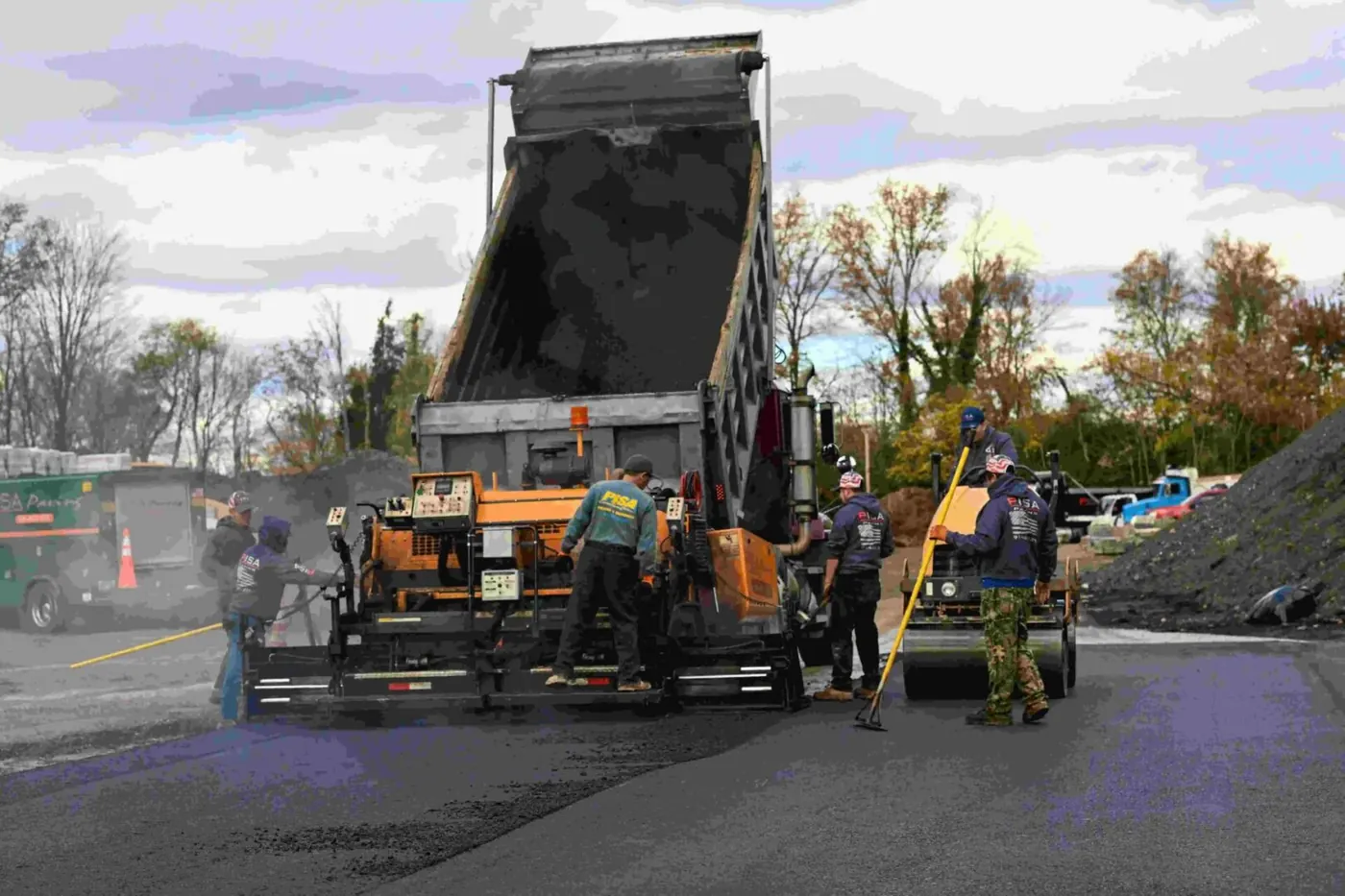Pisa Paving crew spreading hot asphalt behind the paver