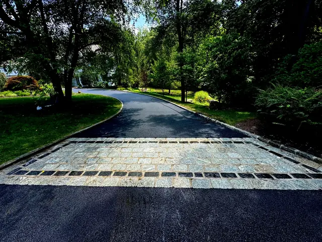 Cobblestone apron at the end of a new asphalt driveway
