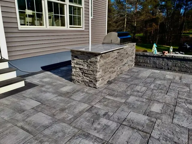 Stone outdoor kitchen on a paver patio